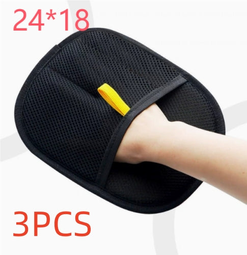 Black pet hair remover mitt worn on a hand with supplier pack label